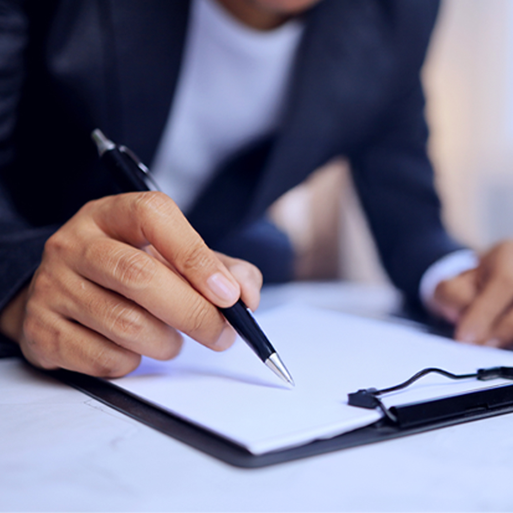 Close-up of a professional hand signing a document on a clipboard, symbolizing business agreements, legal paperwork, or administrative tasks—ideal for digital marketing, finance, and corporate content.